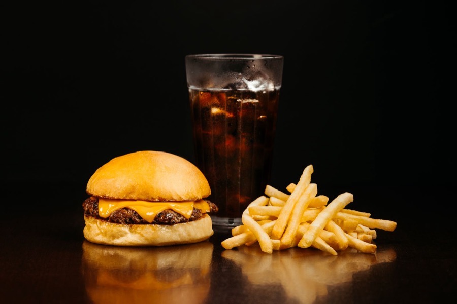 Cheeseburger mit Fries und kaltem Getränk