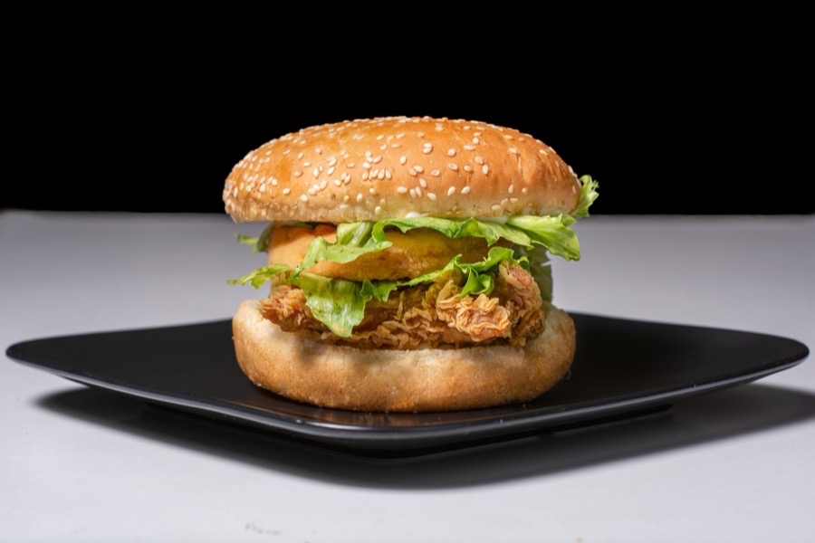 Knuspriger Chickenburger mit Salat auf dunklem Teller